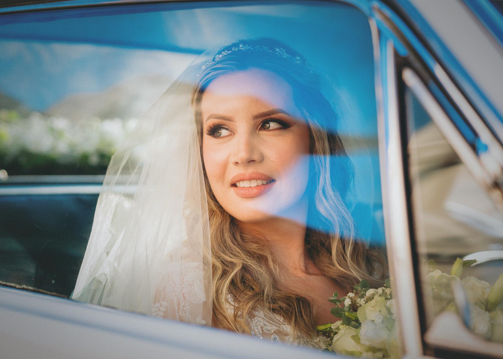 A joyful bride gazing out from a car window in Asunción, Paraguay.